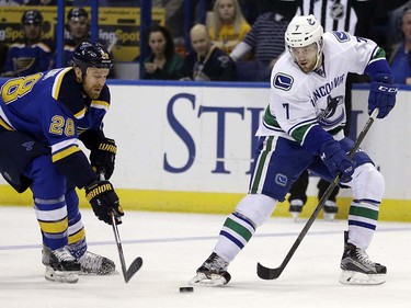 Vancouver Canucks' Linden Vey, right, passes around St. Louis Blues' Kyle Brodziak during the first period of an NHL hockey game Friday, March 25, 2016, in St. Louis. (AP Photo/Jeff Roberson)