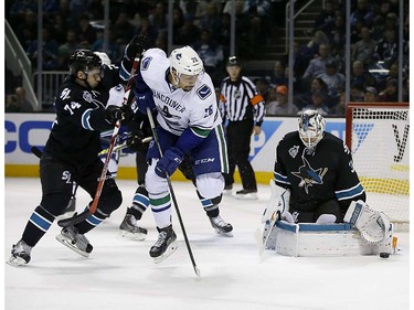 San Jose Sharks goalie Martin Jones (31) blocks a shot from Vancouver Canucks right wing Emerson Etem (26) as Sharks' Dylan DeMelo (74) defends during the second period of an NHL hockey game Thursday, March 31, 2016, in San Jose, Calif. (AP Photo/Tony Avelar)