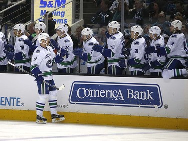 Vancouver Canucks left wing Daniel Sedin (22), of Sweden, celebrates with teammates after scoring a goal against the San Jose Sharks during the first period of an NHL hockey game Thursday, March 31, 2016, in San Jose, Calif. (AP Photo/Tony Avelar)