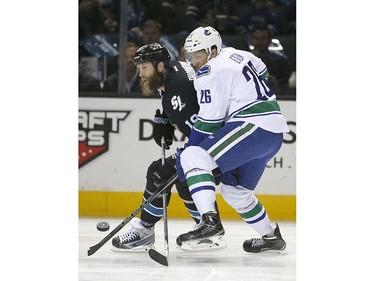 San Jose Sharks center Joe Thornton, left, vies for the puck against Vancouver Canucks right wing Emerson Etem (26) during the first period of an NHL hockey game Thursday, March 31, 2016, in San Jose, Calif. (AP Photo/Tony Avelar)