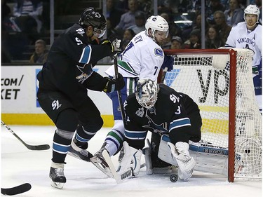 San Jose Sharks goalie Martin Jones (31) blocks a shot from Vancouver Canucks right wing Linden Vey (7) during the second period of an NHL hockey game Thursday, March 31, 2016, in San Jose, Calif. Sharks right wing Dainius Zubrus (9) defends. (AP Photo/Tony Avelar)