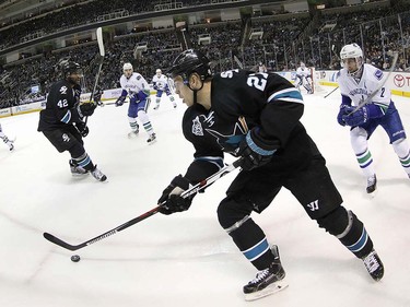 San Jose Sharks right wing Joonas Donskoi (27) moves the puck past Vancouver Canucks defenseman Dan Hamhuis (2) during the first period of an NHL hockey game Thursday, March 31, 2016, in San Jose, Calif. (AP Photo/Tony Avelar)