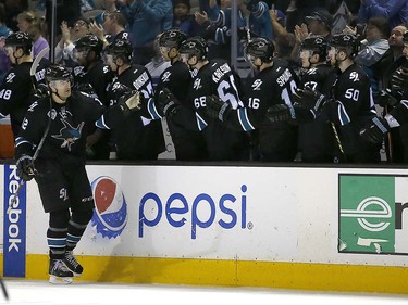 San Jose Sharks center Patrick Marleau (12) is congratulated by teammates on the bench after he scored a goal against the Vancouver Canucks during the second period of an NHL hockey game Thursday, March 31, 2016, in San Jose, Calif. (AP Photo/Tony Avelar)