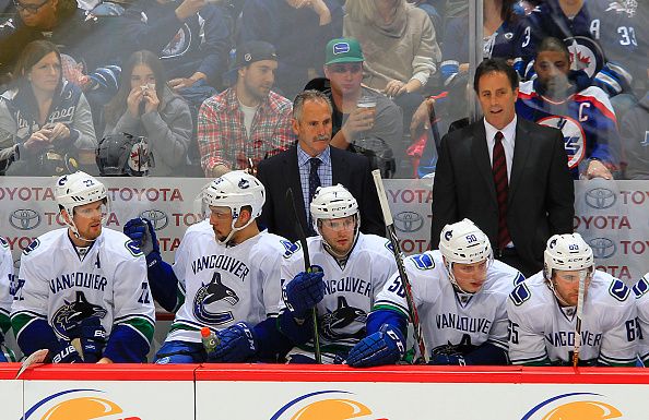 (L-R) Head Coach Willie Desjardins and Assistant Coach Doug Lister of the Vancouver Canucks look on from the bench during second period action against the Winnipeg Jets at the MTS Centre on March 22, 2016 in Winnipeg, Manitoba, Canada. (Photo by Darcy Finley/NHLI via Getty Images)
