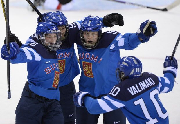 Finland's Jenni Hiirikoski (L) celebrates with teammates after scoring against Switzerland at the Shayba Arena during the Sochi Winter Olympics on February 12, 2014. (AFP PHOTO / JONATHAN NACKSTRAND)