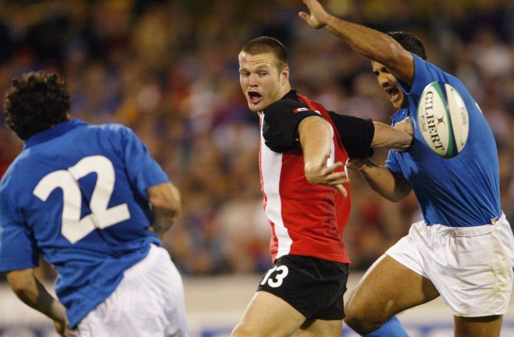 CANBERRA, AUSTRALIA - OCTOBER 21: John Cannon of Canada offloads during the Rugby World Cup Pool D match between Italy and Canada at Canberra Stadium October 21, 2003 in Canberra, Australia. (Photo by Chris McGrath/Getty Images)