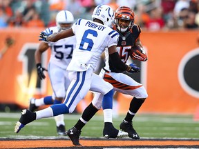 Colin Lockett runs the  ball for the Cincinnati Bengals while the Colts' Loucheiz Purifoy looks to make the tackle in 2014 NFL pre-season action. The pair are now potential B.C. Lions teammates in 2016. (Photo by Andy Lyons/Getty Images)