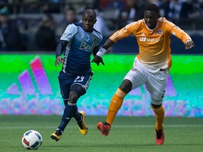 Vancouver Whitecaps Kekuta Manneh, left, moves the ball past Houston Dynamo's Jalil Anibaba during the first half in Vancouver on March 26.