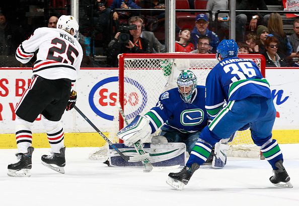 Ryan Miller #30 of the Vancouver Canucks makes a save on Dale Weise #25 of the Chicago Blackhawks in front of Jannik Hansen #36 of the Canucks during their NHL game at Rogers Arena March 27, 2016 in Vancouver, British Columbia, Canada. Chicago won 3-2. (Photo by Jeff Vinnick/NHLI via Getty Images)