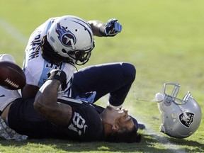 Oakland Raiders tight end Mychal Rivera (81) loses his helmet after being hit by Tennessee Titans free safety Michael Griffin during the second quarter of an NFL football game in Oakland, Calif., Sunday, Nov. 24, 2013. Griffin was penalized on the play and Rivera stayed down for a few minutes before walking off under his own power. He was taken to the locker room and is being evaluated for a head injury.