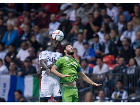 Vancouver Whitecaps Pa-Modou Kah, left, gets his head on the ball behind Seattle Sounders Brad Evans during an MLS game in Vancouver on Sept. 19, 2015. Kah returned to practice this week after nursing a leg injury.