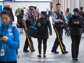 RCMP officers patrol the U.S. check-in area at Vancouver International Airport in Richmond, B.C., on Tuesday. Officials said security at the airport has been heightened after the attack on the Brussels airport in Belgium.