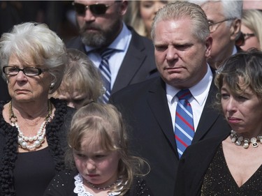 Doug Ford (centre right) cries as he stands with his mother Diane (left) sister-in-law Renata (right) and niece Stephanie as they watch Rob Ford's casket being placed into a hearse following a funeral service at Toronto's St. James Cathedral on Wednesday, March 30, 2016. Ford died of cancer last week at the age of 46.