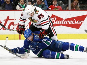 Andrew Shaw #65 of the Chicago Blackhawks checks Henrik Sedin #33 of the Vancouver Canucks during their NHL game at Rogers Arena March 27, 2016 in Vancouver, British Columbia, Canada.  (Photo by Jeff Vinnick/NHLI via Getty Images)