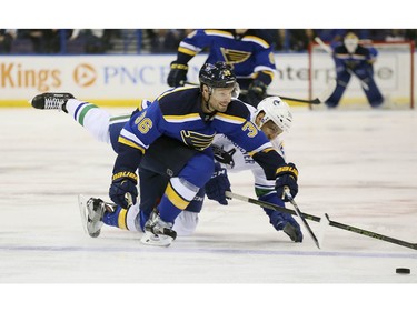 St. Louis Blues right wing Troy Brouwer (36) competes for the puck against Vancouver Canucks right wing Emerson Etem during the first period of an NHL hockey game, Friday, March 25, 2016 in St. Louis.