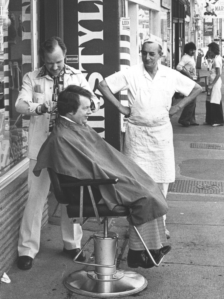 Baker John Smoorenburg came out of his shop to see for himself Monday when barber Corky Knight moved his chair outside in the 3600-block West 4th Avenue following a power outage in the area on April 26, 1977.