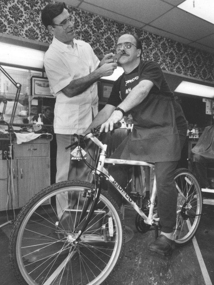 Barber Vincenzio Pecchia trims partner Ron Buter on July 23, 1991