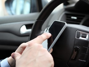 The businessman using mobile smart phone while driving the car.