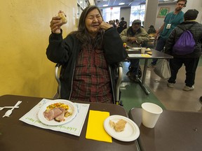 Louise Lagimodiere smiles as she eats during the annual Easter dinner at the Union Gospel Mission.