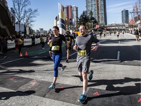 Runners cross the finish line after taking part in Sun Run in Vancouver in 2015.