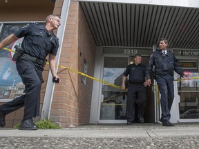 A residence at 3319 Kingsway in Vancouver is taped off on April 14, 2014 after police shot a man suspected in the slaying of a woman and the wounding of a child.