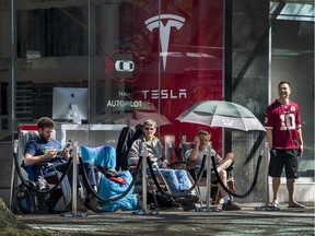 Joseph Preece, left, and Grant Van Dyk, centre, head the line of campers outside the Tesla showroom in downtown Vancouver waiting to put down deposits on the new Model 3.