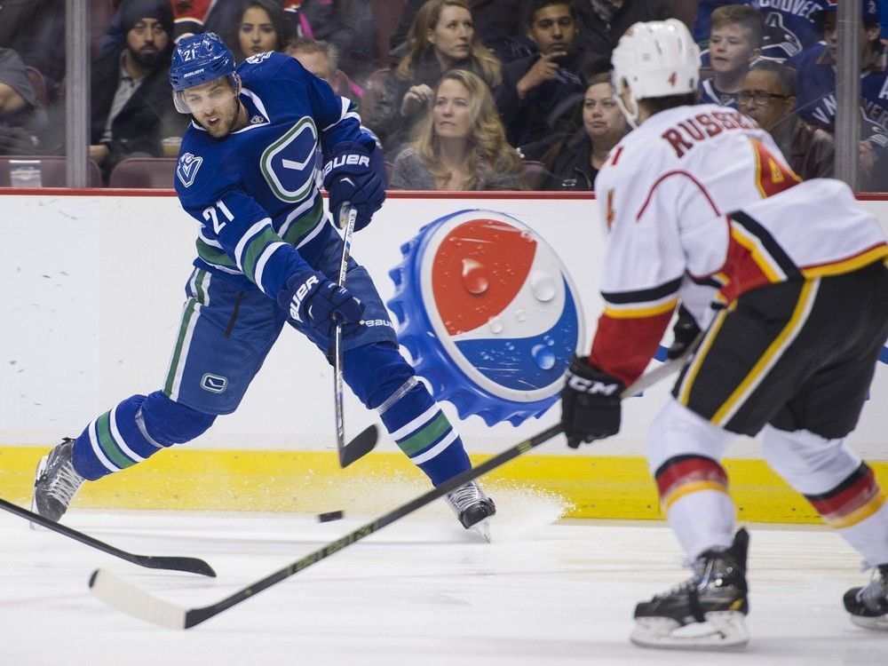 VANCOUVER February 06 2016. Vancouver Canucks #21 Brandon Sutter shoots as Calgary Flames #4 Kris Russell defends in the first period of a regular season NHL hockey game at Rogers Arena, Vancouver, February 06 2016. Gerry Kahrmann / PNG staff photo) / PNG staff photo) ( For Prov / Sun Sports) 00041602A [PNG Merlin Archive]