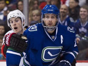 Dan Hamhuis (right, fending off Ottawa Senator Kyle Turris) has relished his role as a mentor to young Canuck players.