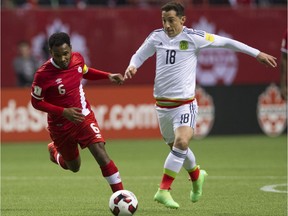 Canada's Julian de Guzman, left, battles Mexico's Andres Guardado for the ball in a FIFA World Cup soccer qualifier at B.C. Place on Friday.