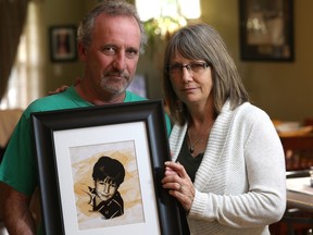 Bruce and Crystal Dunahee hold a photo of their son Michael. — Victoria Times Colonist