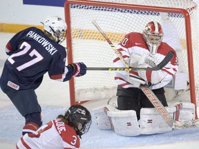 Canada's goaltender Emerance Maschmeyer makes a save as USA's Anne Pankowski looks for the rebound during second period action at the women's world hockey championships Tuesday, March 29, 2016 in Kamloops, B.C. THE CANADIAN PRESS/Ryan Remiorz