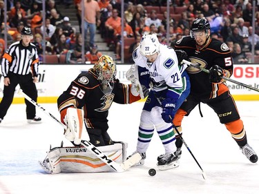 ANAHEIM, CA - APRIL 01:  John Gibson #36 of the Anaheim Ducks stops Daniel Sedin #22 of the Vancouver Canucks as Shea Theodore #53 defends during the second period at Honda Center on April 1, 2016 in Anaheim, California.  (Photo by Harry How/Getty Images)