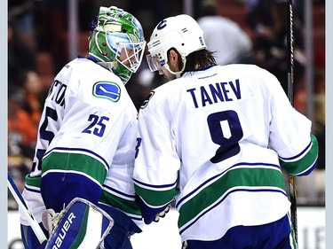 Jacob Markstrom #25 of the Vancouver Canucks and Chris Tanev #8 celebrate a 3-2 win over the Anaheim Ducks during the third period at Honda Center on April 1, 2016 in Anaheim, California.