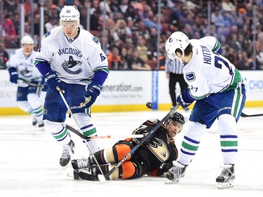 ANAHEIM, CA - APRIL 01:  Andrew Cogliano #7 of the Anaheim Ducks loses falls as he loses the puck between Ben Hutton #27 and Nikita Tryamkin #88 of the Vancouver Canucks during the third period at Honda Center on April 1, 2016 in Anaheim, California.  (Photo by Harry How/Getty Images)
