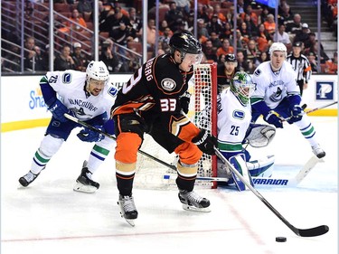 ANAHEIM, CA - APRIL 01:  Jakob Silfverberg #33 of the Anaheim Ducks looks to pass in front of Emerson Etem #26 and Jacob Markstrom #25 of the Vancouver Canucks as he comes from behind the net during a 3-2 Canucks win at Honda Center on April 1, 2016 in Anaheim, California.  (Photo by Harry How/Getty Images)