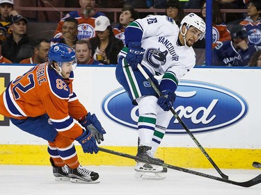 Jordan Oesterle #82 of the Edmonton Oilers defends against Emerson Etem #26 of the Vancouver Canucks on April 6, 2016 at Rexall Place in Edmonton, Alberta, Canada. The game is the final game the Oilers will play at Rexall Place before moving to Rogers Place next season. (Photo by Codie McLachlan/Getty Images)