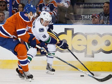 Griffin Reinhart #8 of the Edmonton Oilers defends against Jake Virtanen #18 of the Vancouver Canucks on April 6, 2016 at Rexall Place in Edmonton, Alberta, Canada. The game is the final game the Oilers will play at Rexall Place before moving to Rogers Place next season. (Photo by Codie McLachlan/Getty Images)