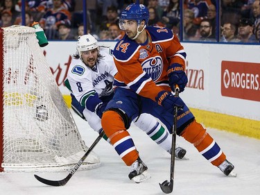 Jordan Eberle #14 of the Edmonton Oilers is pursued by Christopher Tanev #8 of the Vancouver Canucks on April 6, 2016 at Rexall Place in Edmonton, Alberta, Canada. The game is the final game the Oilers will play at Rexall Place before moving to Rogers Place next season. (Photo by Codie McLachlan/Getty Images)