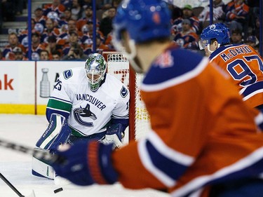 Taylor Hall #4 and Connor McDavid #97 of the Edmonton Oilers keep their eyes on the puck as goaltender Jacob Markstrom #25 of the Vancouver Canucks makes a save on April 6, 2016 at Rexall Place in Edmonton, Alberta, Canada. The game is the final game the Oilers will play at Rexall Place before moving to Rogers Place next season. (Photo by Codie McLachlan/Getty Images)