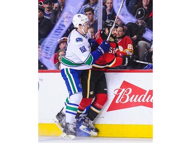 Nikita Tryamkin #88 of the Vancouver Canucks checks Brandon Bollig #52 of the Calgary Flames during an NHL game at Scotiabank Saddledome on April 7, 2016 in Calgary, Alberta, Canada. (Photo by Derek Leung/Getty Images)