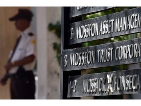 A journalist takes pictures Tuesday of the facade of the building where Panama-based Mossack Fonseca law firm offices are in Panama City.