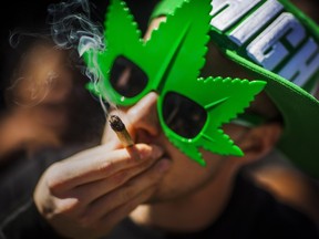 A man smokes a marijuana joint during the "420 Toronto" rally in Toronto, Wednesday April 20, 2016.