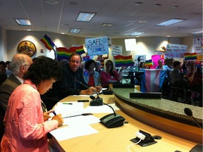 A sea of signs at the Vancouver school board meeting on Monday, June 6, where the board voted in favour of a plan to put gender-neutral washrooms in schools and support students in expressing their preferred gender identities. Trustee Fraser Ballantyne (facing camera) looks on as fellow board members Ken Denike and Sophia Woo prepare to argue for more consultation on the policy. Matt Robinson/Vancouver Sun [PNG Merlin Archive]