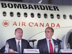 Calin Rovinescu, right, president and CEO of Air Canada, listens to Alain Bellemare, president and CEO of Bombardier Inc., during a news conference Wednesday, February 17, 2016 in Montreal. Bombardier has a deal to sell Air Canada 45 CSeries jets, with an option to buy up to 30 more. Bombardier also announced Wednesday it will eliminate 7,000 positions over two years.