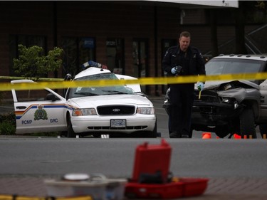 An Investigator examines the scene of the crash involving a police car and a pickup truck in Langford, B.C., Tuesday, April 5, 2016. RCMP Const. Sarah Beckett was killed in the crash.