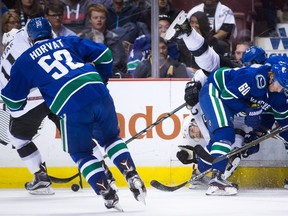 Defenceman Drew Doughty of the Los Angeles Kings is upended by Chris Tanev of the Vancouver Canucks behind Markus Granland. The Kings' Anze Kopitar takes control of the puck while Bo Horvat of the Canucks gives chase during Monday's NHL action at Rogers Arena.