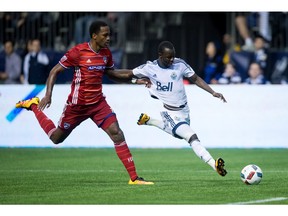 Vancouver Whitecaps’ Kekuta Manneh, right, takes a shot as FC Dallas’s Atiba Harris defends last Saturday. The Caps’ season may have turned for the better when Manneh had a shot bounce in off the Dallas goalie and a defender.