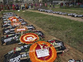 Bangladeshi social acctivists and relatives of victims of the Rana Plaza building collapse pay their respects at a graveyard in Dhaka on April 24, 2016, as they mark the third anniversary of the disaster. Thousands of Bangladeshi garment workers demanded justice and safe work places as they marked the third anniversary of the Rana Plaza factory disaster that killed over 1,100 people. /