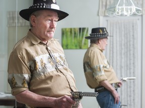 Dennis Robinson is reflected in a mirror as he demonstrates a fast draw.