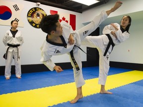 Seongwoo Eom (centre) and Emily Kim train under the watchful eye of Master Oh at the SC Kim's Taekwondo dojo in Burnaby. The two young people are training to compete for spots on the Canadian National Junior team.